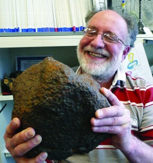 鉴定专家抱着“汇念陨石”，上图为 “汇念陨石”的横截面